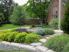The upper terraced planting includes a secondary stone path down to the lower lawn.