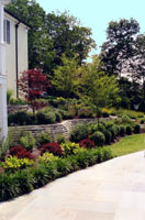 A series of stone walls terraces the hillside and pathway down to the pool.