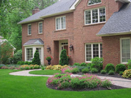 Sweeping  wide entry walk with planting beds on both sides makes an interesting journey to the front door.
