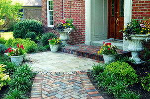 Seasonal container garden punctuate the oversized front entry pad.